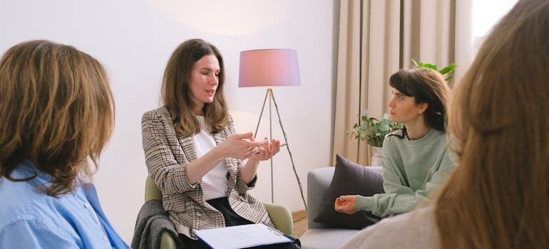 Therapist talking to people in a group therapy session.