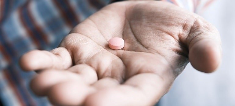 Man offering prescription drug in his hand.