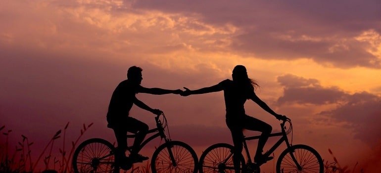 People who are dating are riding bicycles together.