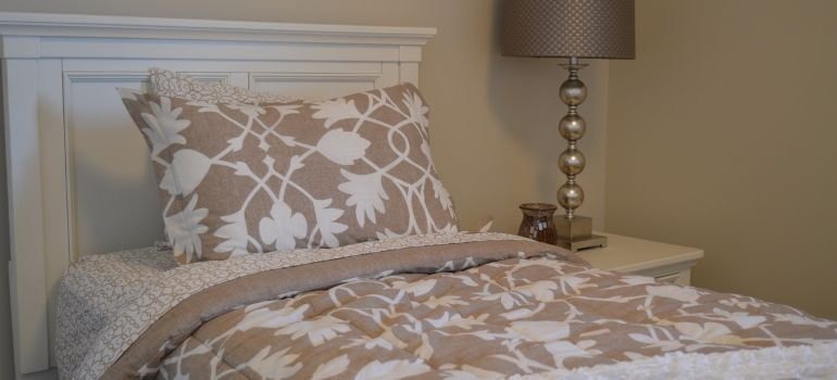 A bed and a lamp next to it.