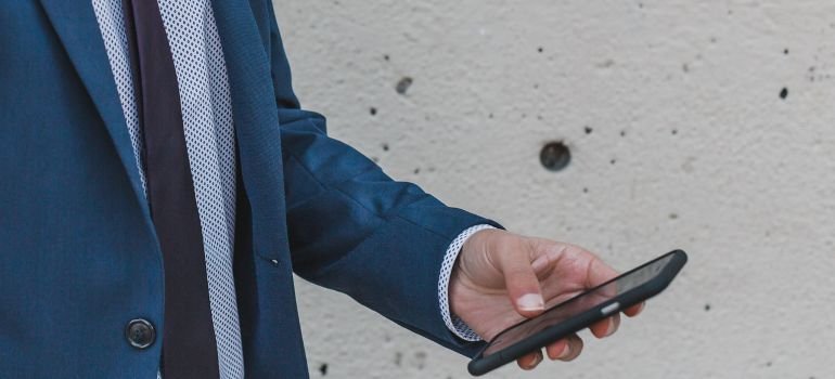 A man holding a phone, about to contact rehab Wilkes Barre PA center. 
