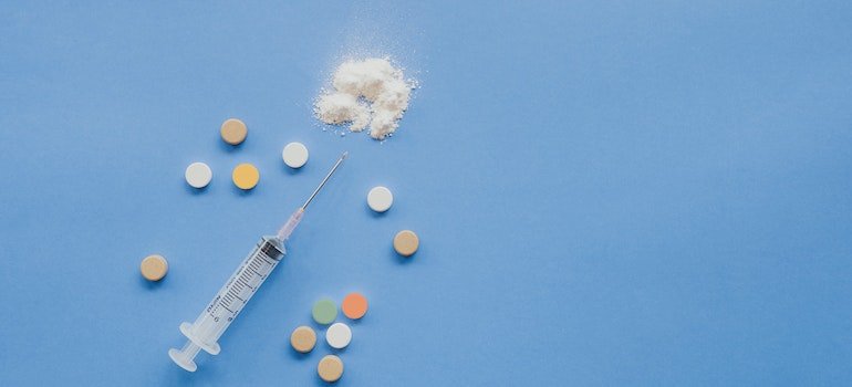 Drugs and syringe on a blue surface
