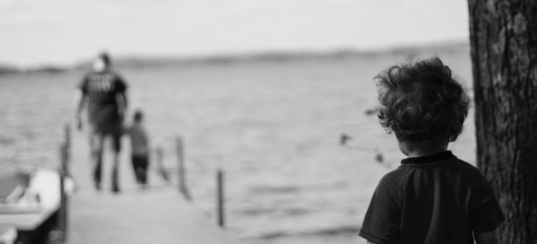 A lonely child watches his father and sibling leave.