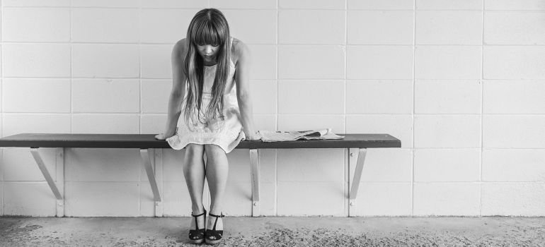 A girl sitting on a bench, contemplating long-term effects of meth.