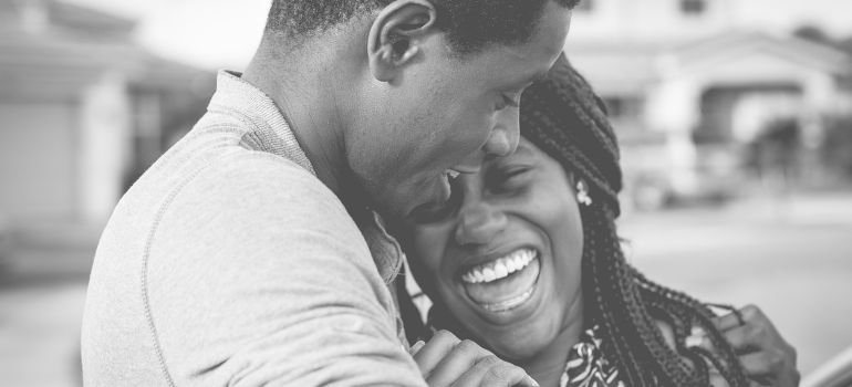 A man and a woman hugging and laughing.