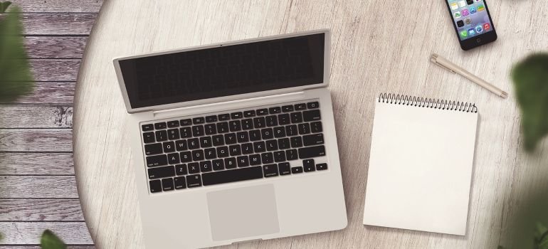 A notepad next to a laptop.