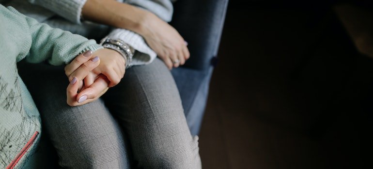 A parent holding a child's hand.