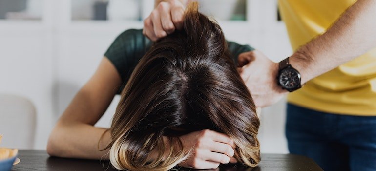 A woman being held down by a man.