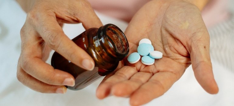 a woman taking prescription drugs out of the bottle