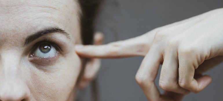 person pointing at their head