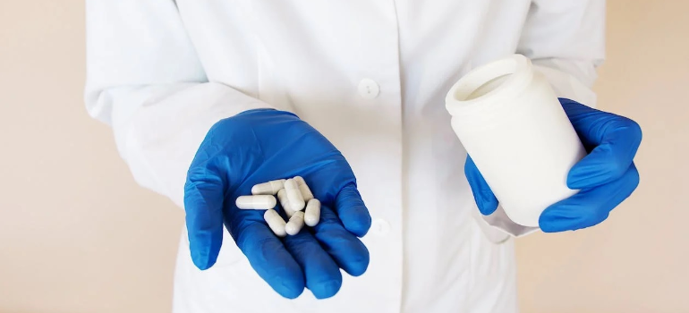 A medical professional presenting pills for an opiate detox PA program representing Pennsylvania opioid treatment programs