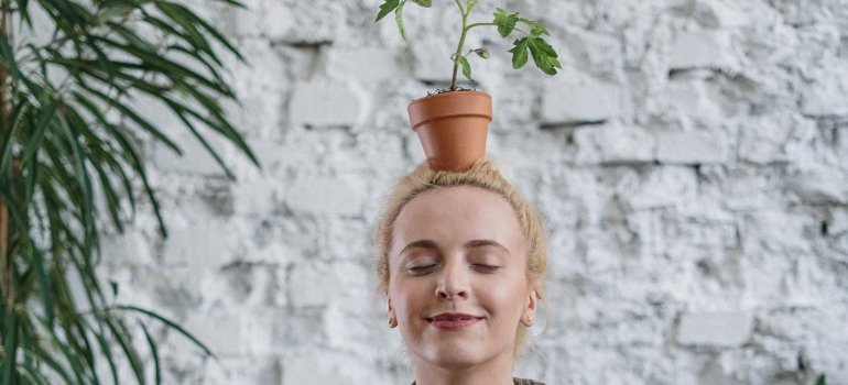 person holding a potted plant on their head