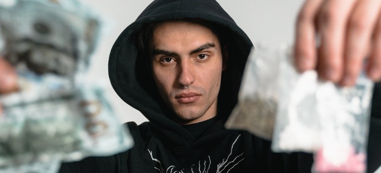 person holding packets of cocaine, symbolizing the link between domestic violence & addiction in Pennsylvania