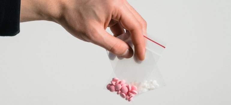 person holding two drug packets