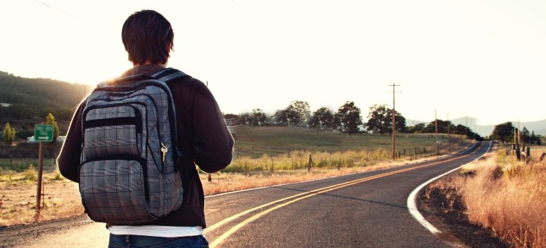 person walking on an asphalt road