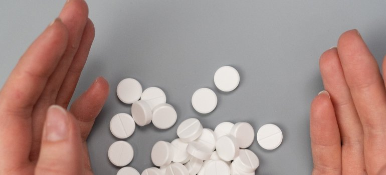 two hands near benzodiazepine tablets