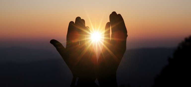 Hopeful hands closing in to hold the sun