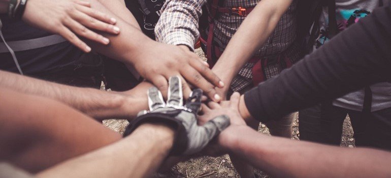People putting hands together to show support from recovery communities.