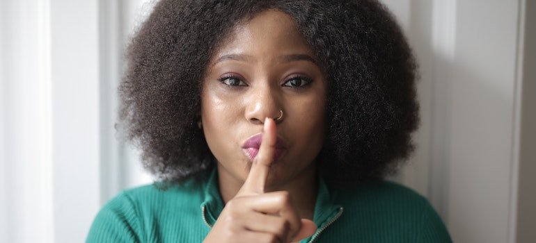 woman doing shhh hand gesture