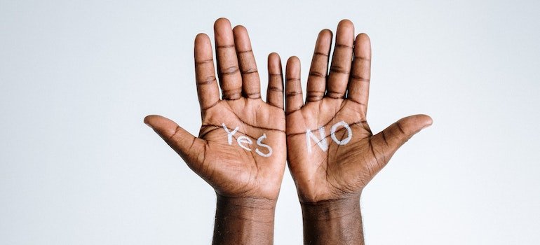 A person's hands with yes and no written on them