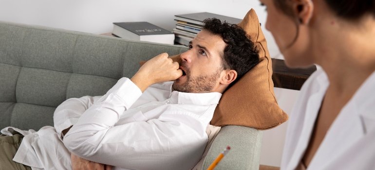 Middle aged man thinking infront of psychiatrist