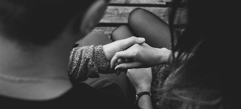 Two persons holding hands, man having meth addiction.