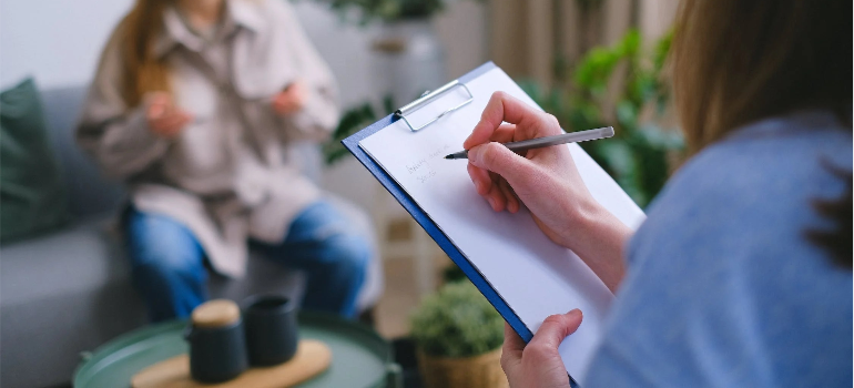A psychologist keeping notes during a psychotherapy session.