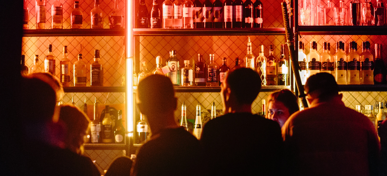 A lot of people at the bar ordering drinks.