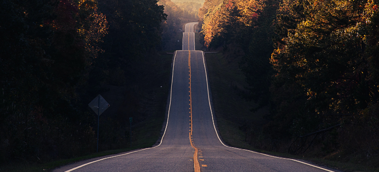 A road going uphill with nature around it.