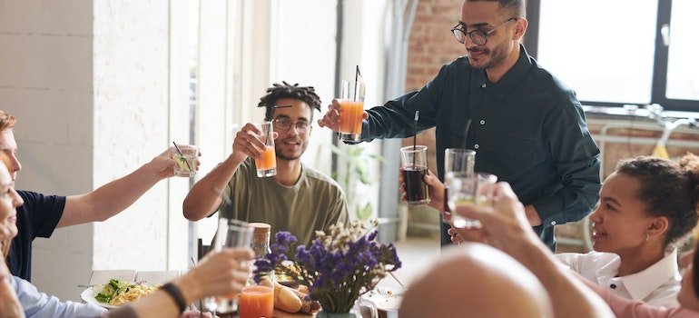 family and friends at a thanksgiving table cheering with non-alcoholic drink