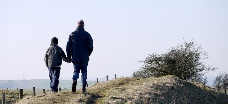 Father and son walking on beach.