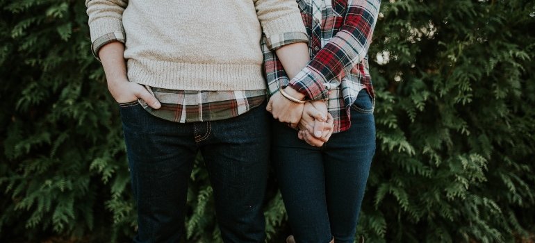 Couple holding hands and standing next to each other