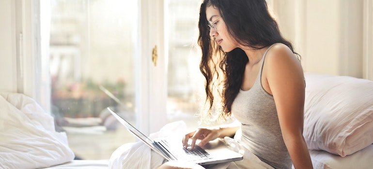 a young woman reading on a laptop about the power of patience in recovery