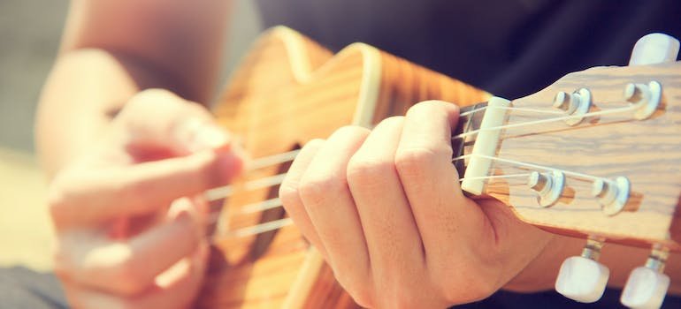 person playing a brown ukulele