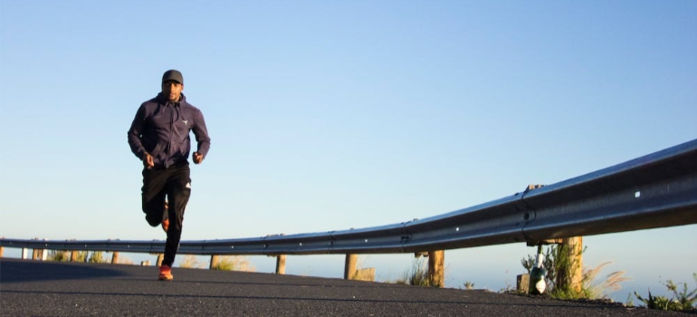 A man jogging during daytime, illustrating the impact of sports and physical activity in Pennsylvania.