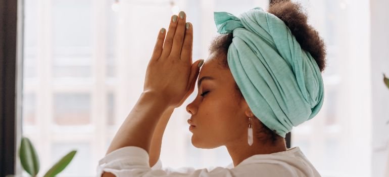 person meditating with palms in front of face