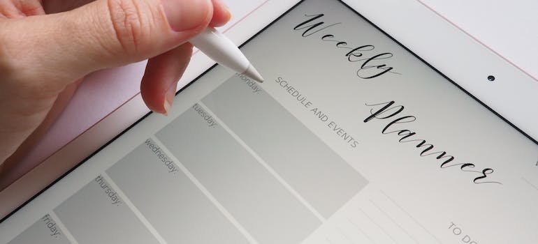 woman writing a weekly plan on a tablet