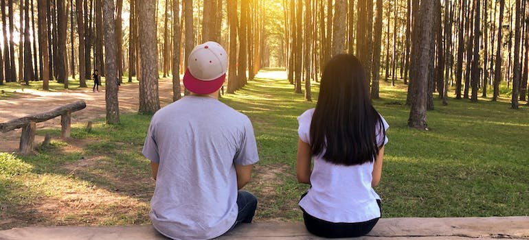 a man and the woman's back while sitting on the bench