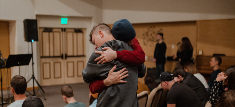 Two men hugging in therapy.