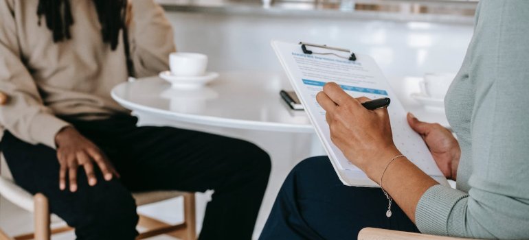 a therapist talking to a patient and taking notes representing Coping Strategies for Pennsylvania Families Dealing with a Loved One's Addiction 