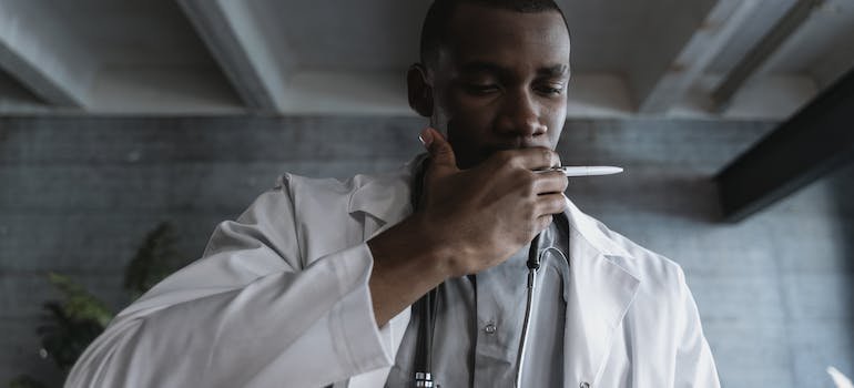 a doctor holding his hand over his mouth