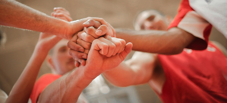 supportive people joining hands together