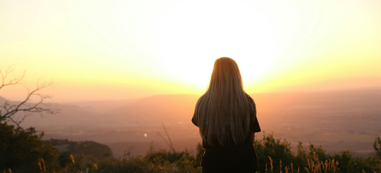 a woman looking at the sunset