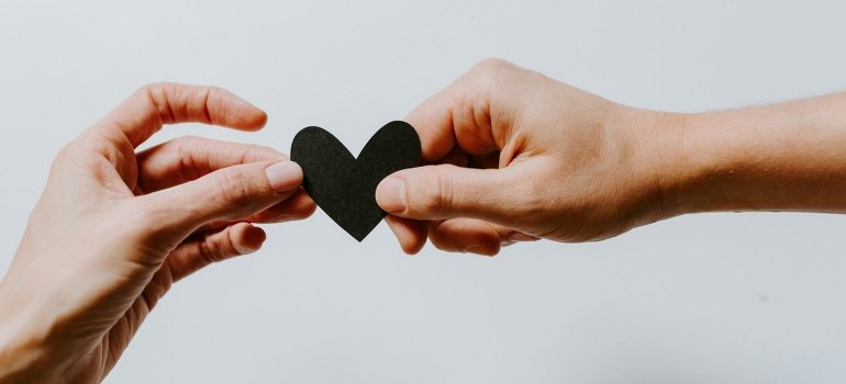 Two people holding a paper cutout of a heart.