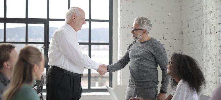 Seniors shaking hands after talking about veterans' substance abuse stats for NJ and NY.