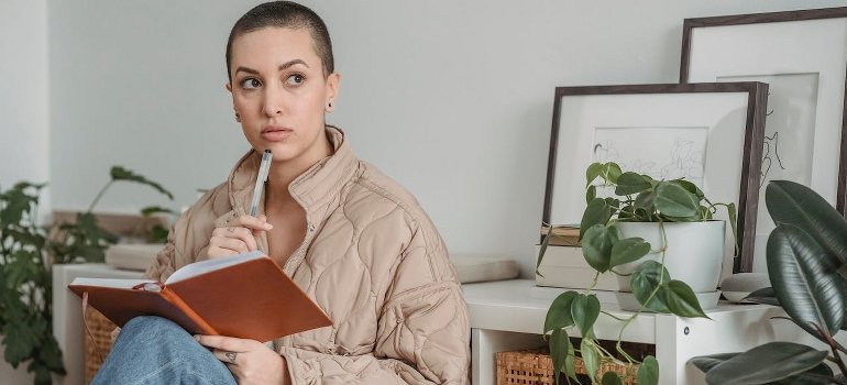 A woman is holding a notebook. 