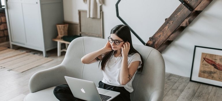 A woman is thinking of healthy coping skills and using earphones to relax in her free time. 