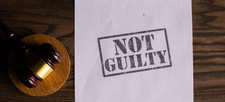 a "not guilty" sign on a piece of paper next to a gave representing why drinking games are a concern for Pennsylvania's college students