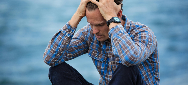 a man holding his head because he is a high functioning addict 