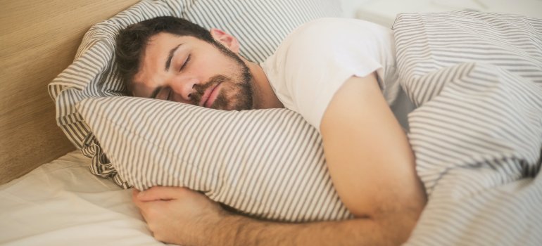 A man sleeping in bed. The first step towards healing your brain after addiction.